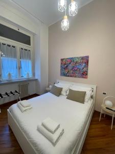 a bedroom with a large white bed with towels on it at Miramare Serenella in Genoa
