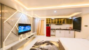 a living room with a kitchen and a red refrigerator at Spacious studio with balcony, 10mins to the beach in Victoria Island +7 photos
