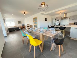 a dining room and kitchen with a table and chairs at Maison spacieuse pour 8 personnes, proche GR34 in Sibiril