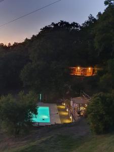 a swimming pool at night with a house in the background at Podere Bellavista in Monterotondo +13 photos
