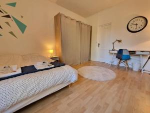 une chambre avec un lit et une horloge au mur dans l'établissement Mont d'arène superbe appartement proche gare, à Reims