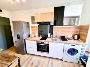 une cuisine avec une machine à laver et un lave-linge dans l'établissement Mont d'arène superbe appartement proche gare, à Reims