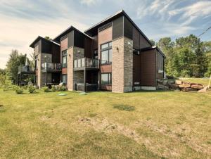 ein großes Haus mit einem Garten davor in der Unterkunft Condo Matha in Saint-Jean-de-Matha