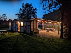 a tiny house with lights in a yard at night at Wagonlit 27 in Civières