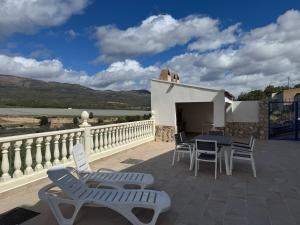 a patio with a table and chairs on a balcony at Casa Nuevos Vientos CR Los Cuatro Vientos in Moratalla