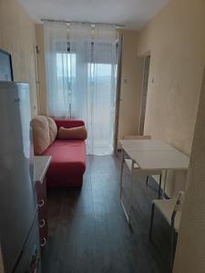 Una sala de estar con un sofá rojo y una mesa. en City apartmant, en Tuzla