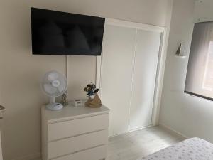 a bedroom with a dresser with a tv on the wall at Panxon Madorra Mar in Panjón