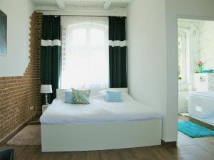 a bedroom with a bed and a window and a tub at Apartamenty Lux Chorzów in Chorzów