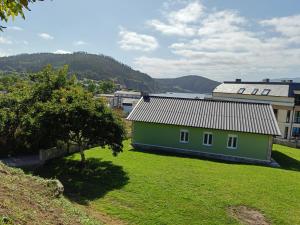 a green house on a grassy field next to a building at Casa do Olmo in Porto de Espasante