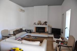 a living room with white furniture and a fireplace at Zeus House by GHH in Hydra