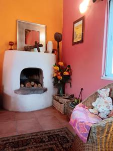 Una sala de estar con chimenea y un sofá. en Casa da Casimira, en Miranda do Corvo