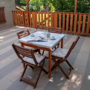 a table with two chairs and a book on a patio at Marilla Apartman in Tata