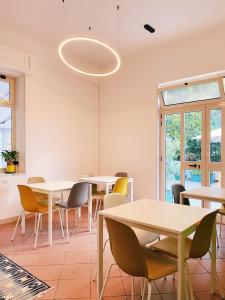 a dining room with white tables and yellow chairs at b&b L`Oasi in Casal Velino