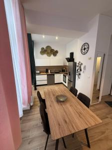 a dining room with a wooden table and chairs at Grand F2 centre-ville, parking privée in Auxerre