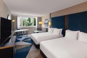 维也纳Hilton Vienna Waterfront的有两张床和一台电视的酒店房间
