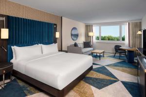 维也纳Hilton Vienna Waterfront的一间带大床的卧室和一间客厅 更多37张照片