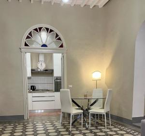 a dining room with a table and white chairs at La Casina in Città della Pieve