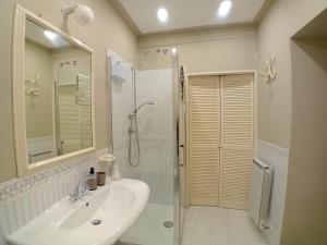 a white bathroom with a sink and a shower at La Casina in Città della Pieve