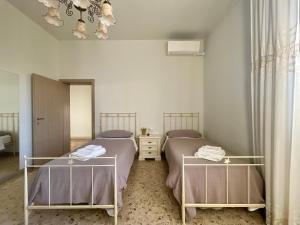 Un dormitorio con dos camas y una lámpara de araña. en A Casa Di Mima, en Civitanova Marche