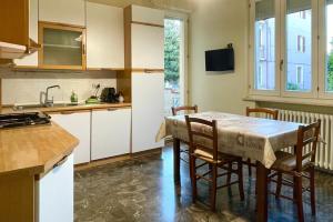 Una cocina con una mesa y sillas y un fregadero. en A Casa Di Mima, en Civitanova Marche