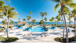 a resort with a pool and palm trees and the ocean at Hilton Ponce Golf & Casino Resort in Ponce