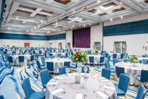 a banquet hall with white tables and blue chairs at Hilton Ponce Golf & Casino Resort in Ponce +37 photos