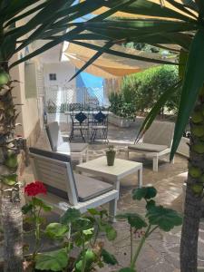 a patio with chairs and tables and an umbrella at Oikos Noemi in Palinuro