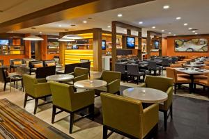 a restaurant with tables and chairs in a room at Hilton Mississauga/Meadowvale in Mississauga
