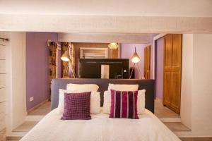 Un dormitorio con una cama grande con paredes moradas. en Le Hameau Fleur de Pierres , Chambre , Gite et Table d'Hôtes, en Murs 87 fotos más