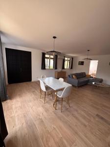 a living room with a table and chairs and a couch at La maison du vignoble in Beine