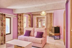 Una sala de estar con un sofá y paredes moradas. en Le Hameau Fleur de Pierres , Chambre , Gite et Table d'Hôtes, en Murs