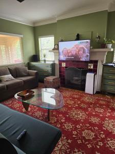 a living room with a couch and a flat screen tv at The Gingko House in Pasadena