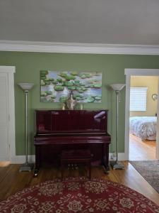 a piano in a living room with a bedroom at The Gingko House in Pasadena