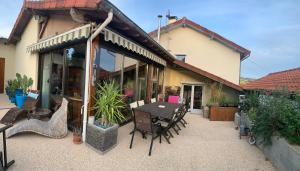 a patio with a table and chairs outside of a house at Le Verdier in Chauffailles