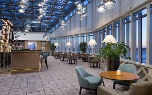 a lobby with tables and chairs in a building at DoubleTree By Hilton Moscow - Vnukovo Airport Hotel in Vnukovo