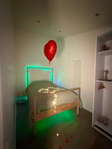 a room with a bed with a red balloon at SPA JUNGLE in Le Mesnil-Saint-Denis