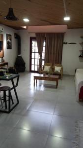a living room with a bed and a couch and a table at Casa da Maria in Bagé +8 photos