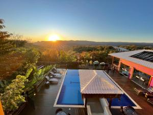 a view of a resort with a pool and the sunset at Villa Tereza in Alto Paraíso de Goiás