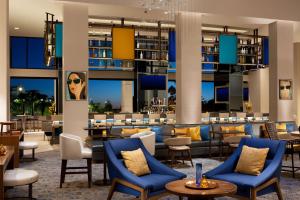 a lobby of a hotel with blue chairs and a bar at Hilton Orlando Buena Vista Palace - Disney Springs Area in Orlando