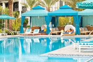 a group of people sitting in chairs by a swimming pool at Hilton Orlando Buena Vista Palace - Disney Springs Area in Orlando