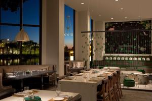 a restaurant with tables and chairs and a large window at Hilton Orlando Buena Vista Palace - Disney Springs Area in Orlando