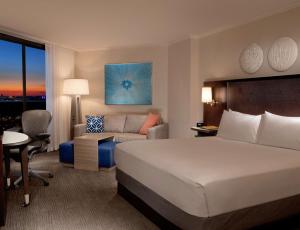 a hotel room with a bed and a couch at Hilton Orlando Buena Vista Palace - Disney Springs Area in Orlando