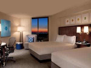 a hotel room with two beds and a desk at Hilton Orlando Buena Vista Palace - Disney Springs Area in Orlando