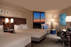 a hotel room with two beds and a desk at Hilton Orlando Buena Vista Palace - Disney Springs Area in Orlando