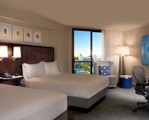 a hotel room with two beds and a balcony at Hilton Orlando Buena Vista Palace - Disney Springs Area in Orlando