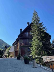 a large wooden house with a pine tree in front of it at Ochalet Bagergue in Bagergue +50 photos