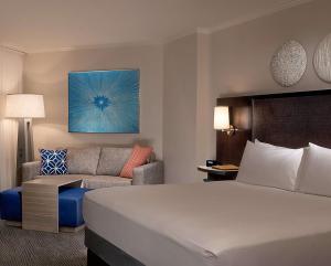 a hotel room with a bed and a couch at Hilton Orlando Buena Vista Palace - Disney Springs Area in Orlando