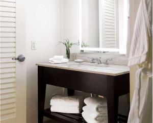 a bathroom with a sink and a mirror and towels at Hilton Orlando Buena Vista Palace - Disney Springs Area in Orlando