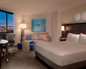 a hotel room with a bed and a couch at Hilton Orlando Buena Vista Palace - Disney Springs Area in Orlando