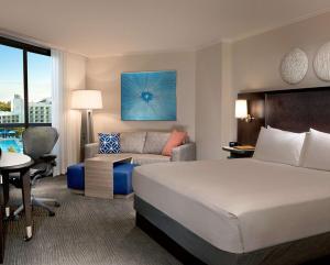 a hotel room with a bed and a couch at Hilton Orlando Buena Vista Palace - Disney Springs Area in Orlando